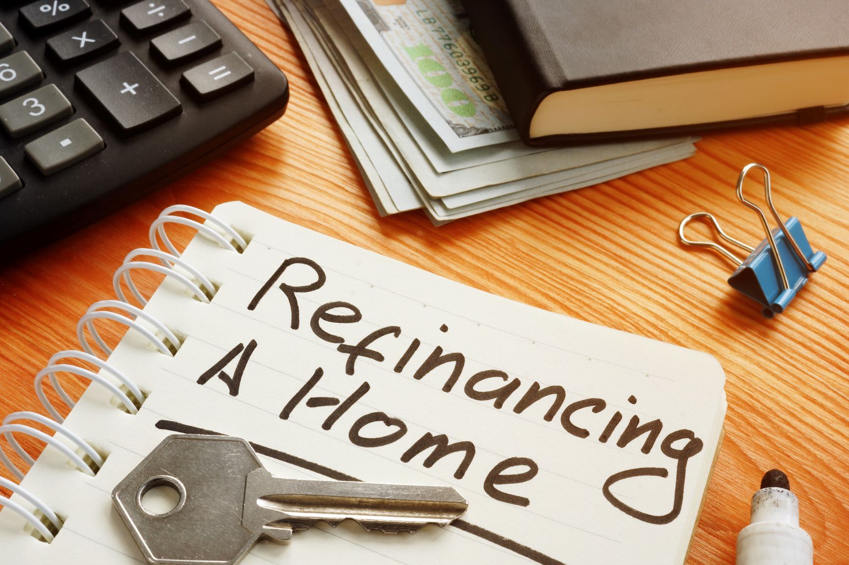 a notepad with "refinancing a home" written on the page