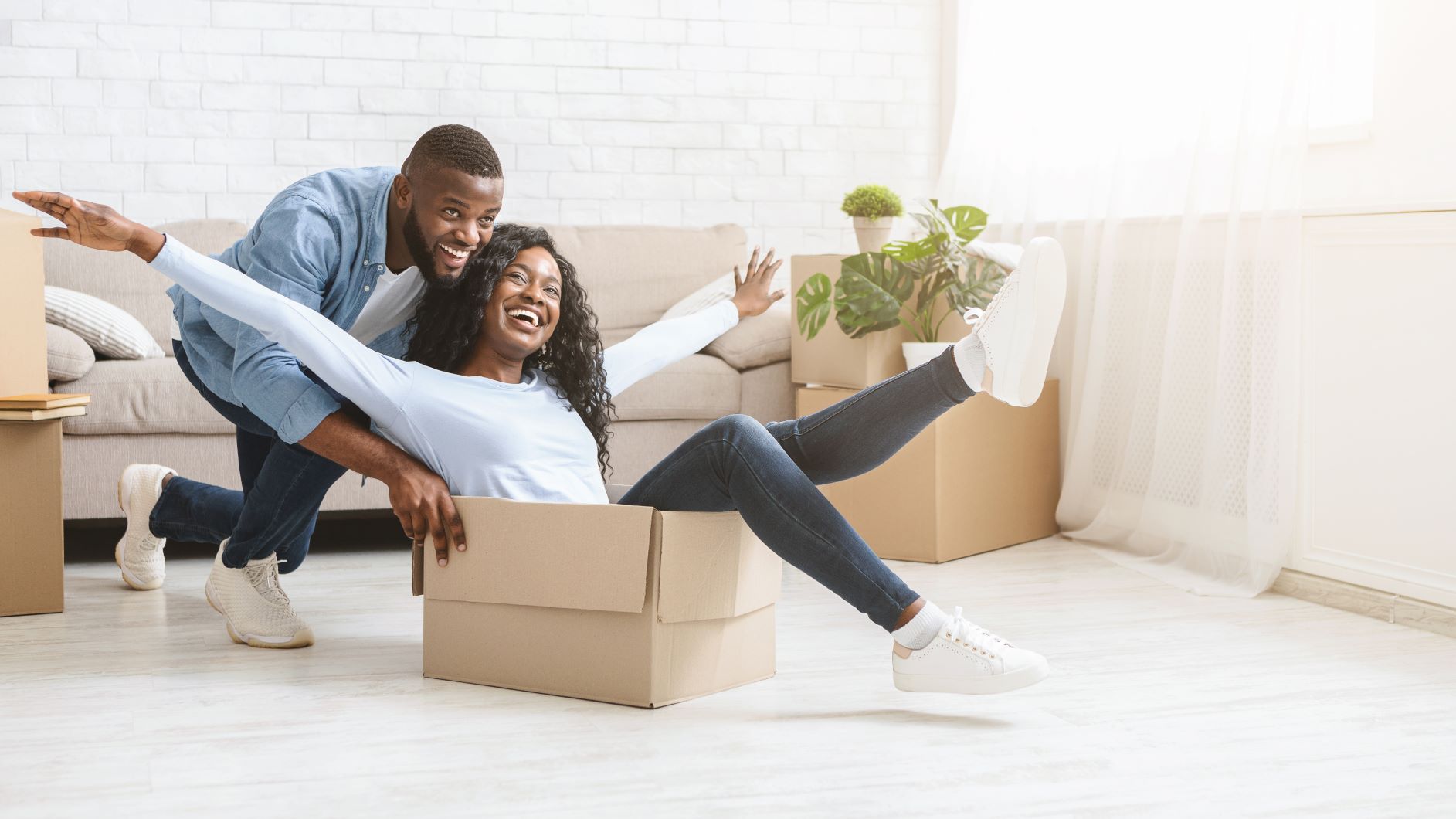 Man pushing happy woman in moving box