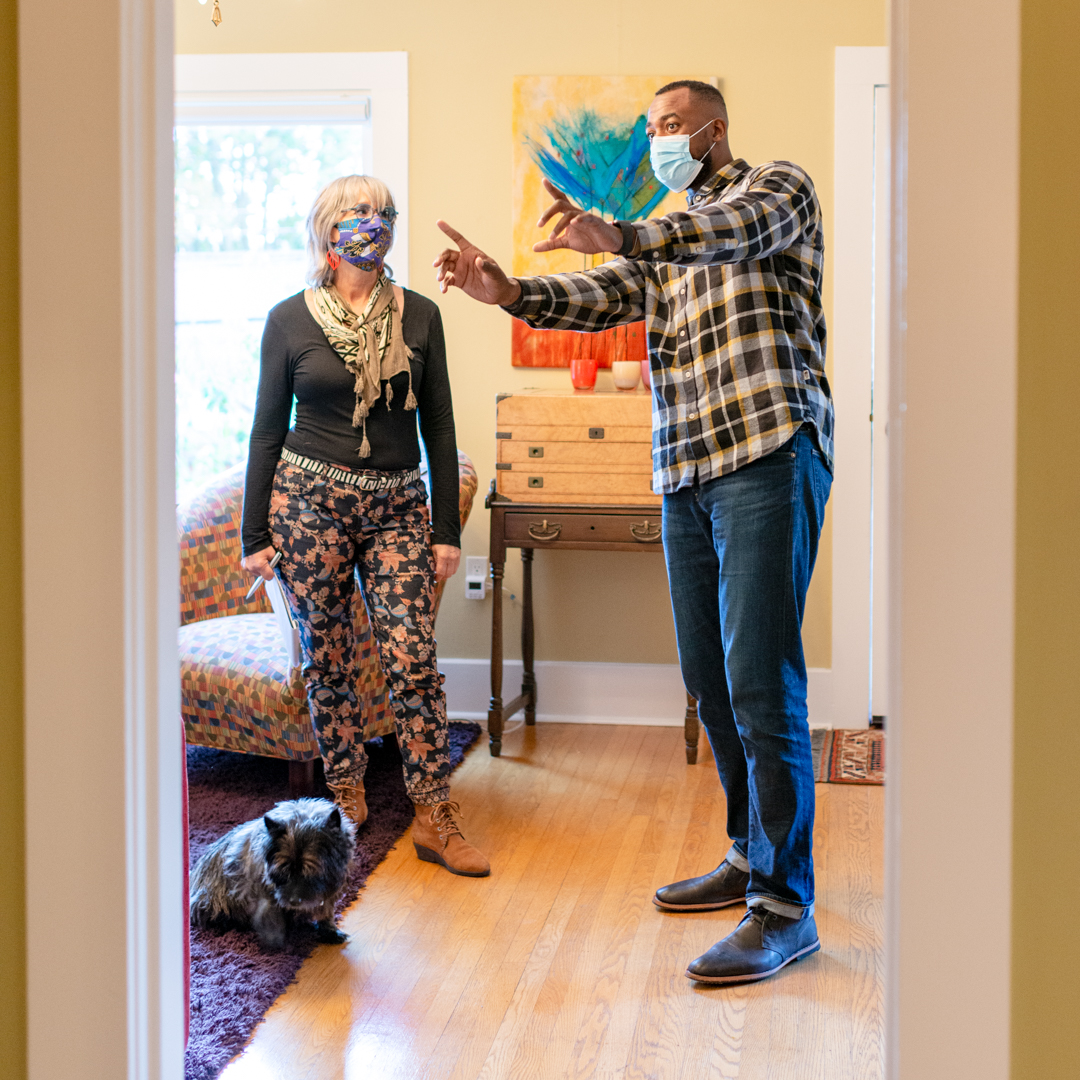 real estate agent and woman touring house, wearing masks